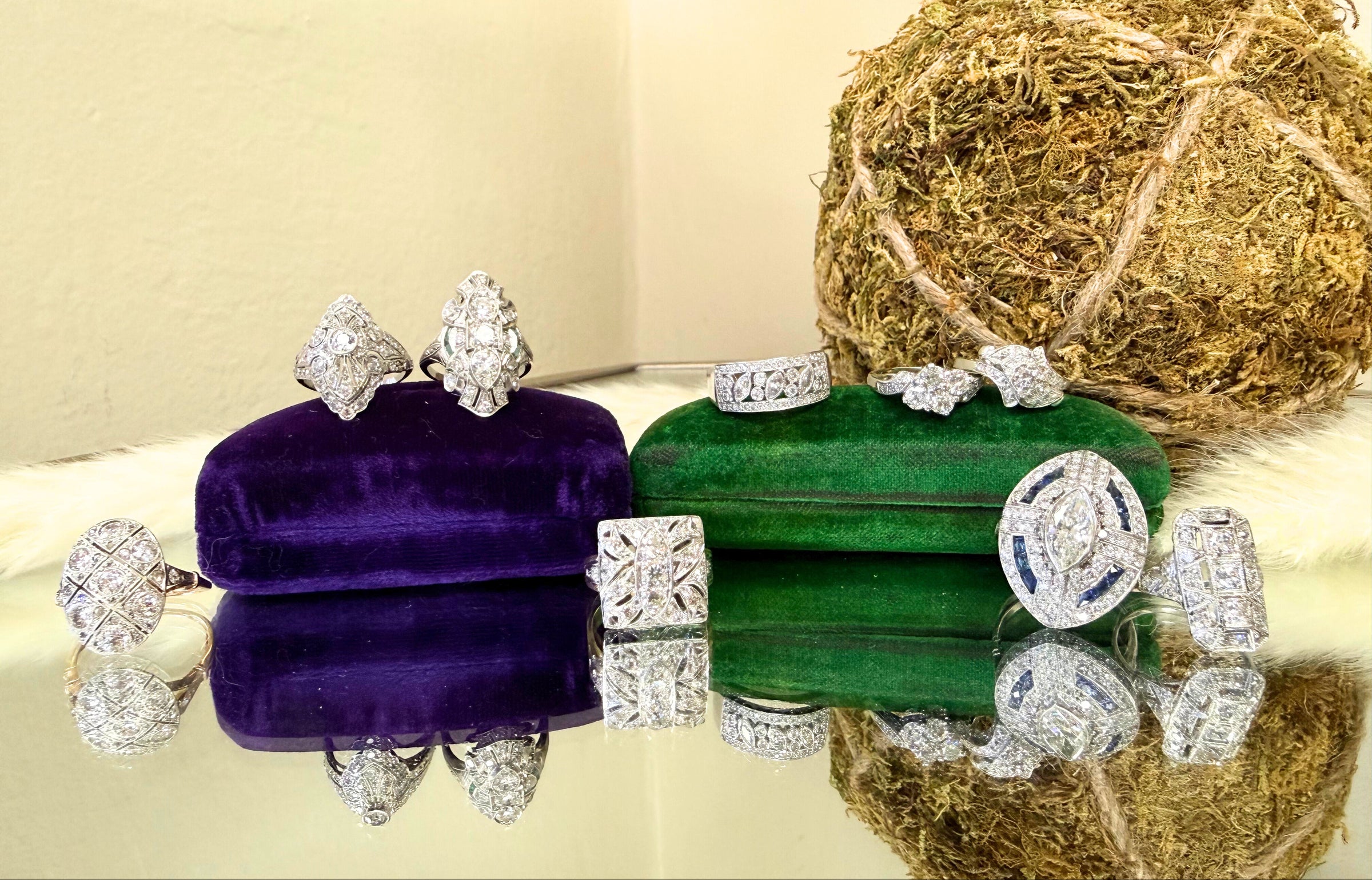 Diamond earrings displayed on purple and green stands with a textured background