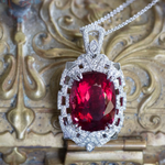 Welcome to true, luxury jewelry.  This is perhaps our most extravagant handcrafted piece to date, featuring a natural cushion shaped rubellite tourmaline from Brazil.  The stone has a red hue with hints of peachy pink depending on the viewing angle.  The stone is untreated and weighs 21.02ct.  We've set it securely with double claw prongs in a diamond-rich Art Deco inspired setting.  The pendant features just under a carat of F/G color, VS2 clarity full cut diamonds, highlighted with layers of piercing and 